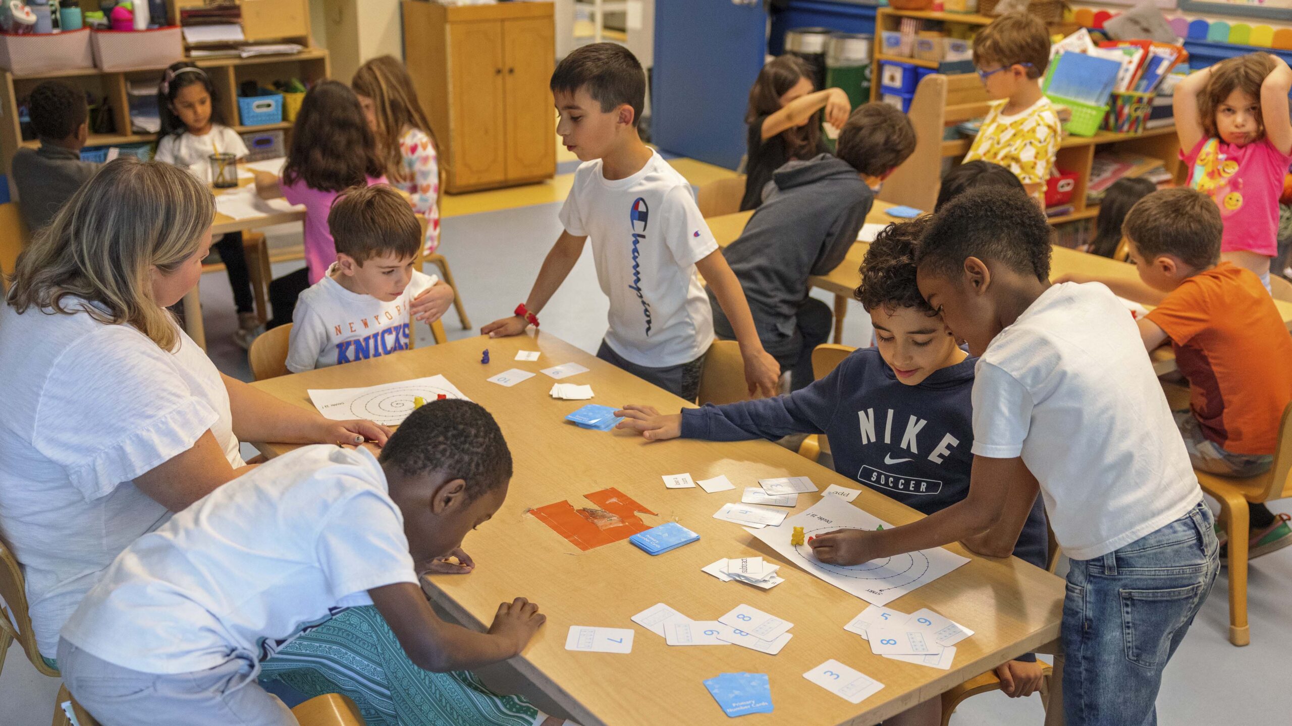 Students and teachers work around a table. 