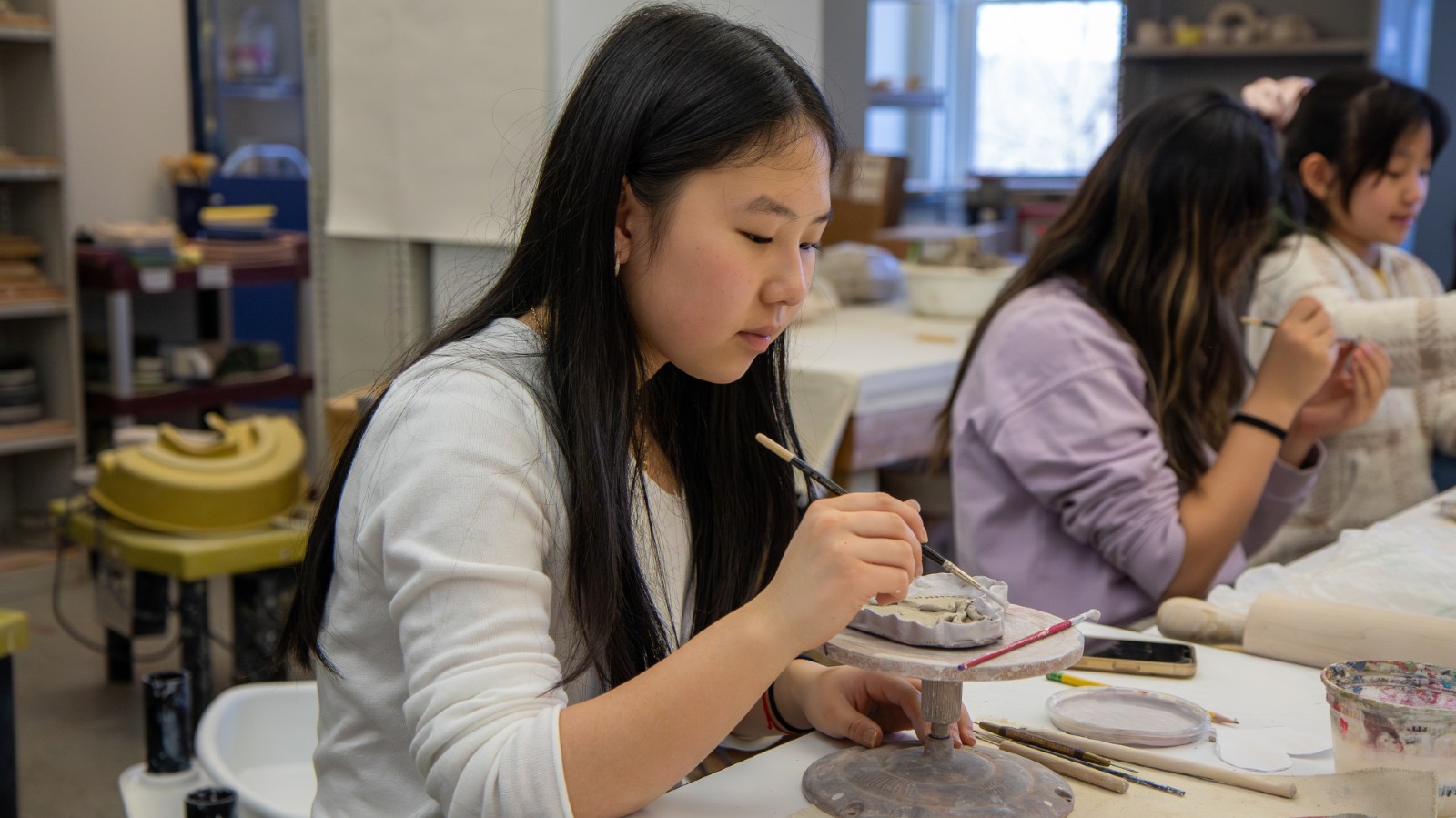 Middle School student shaping clay.